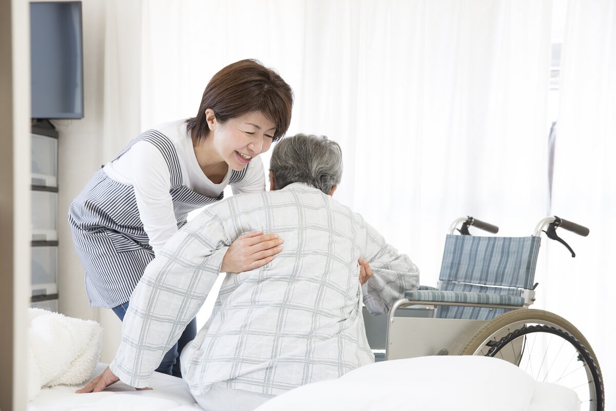 60歳の介護士が特別養護老人ホームで介助している様子
